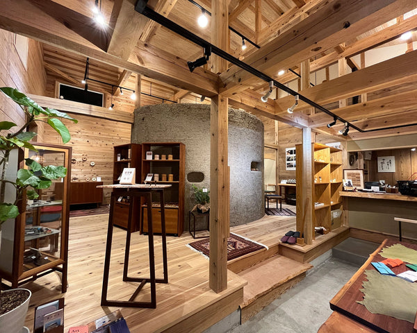 手神（TEGAMI）ポップアップショップ内観 - 自然素材の木造建築と土壁の展示空間。木製梁と木の温もりあふれる和モダンな木製品ギャラリー。千葉県長南町大谷家具製作所での木製インテリア展示