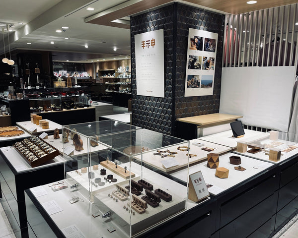 横浜高島屋の手神ポップアップショップ、ガラスケース内に木製品が展示されている