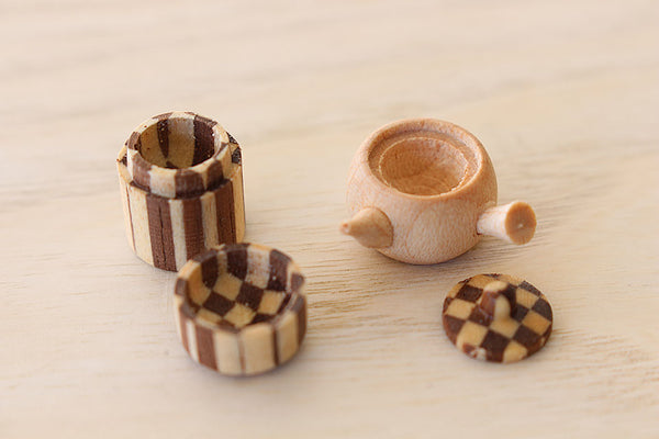 蓋を外した豆和茶器の急須と茶筒。内部まで丁寧に挽き込まれた職人技が光る極小の木工芸品。