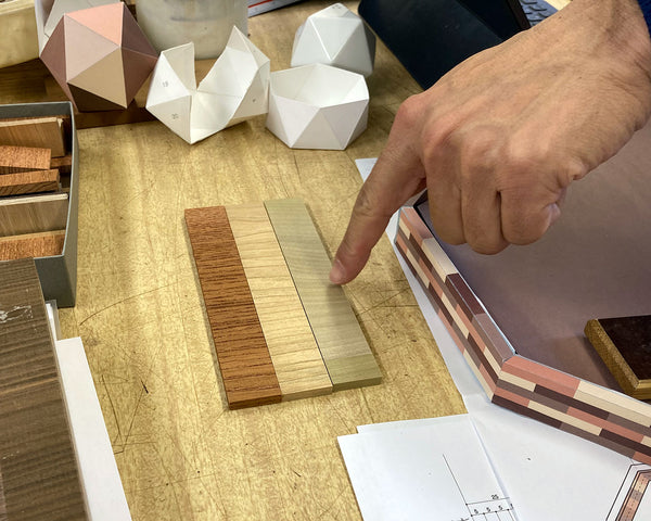 商品に適した木材の提案。樹種サンプルや図面を前に素材を検討する様子。